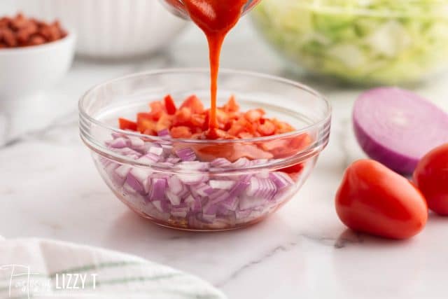 french dressing pouring over onions and tomatoes