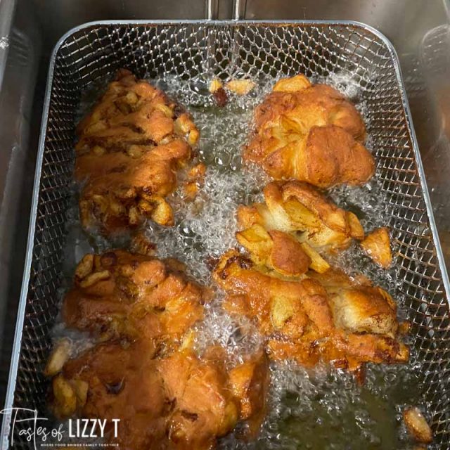 golden brown apple fritters in a deep fryer