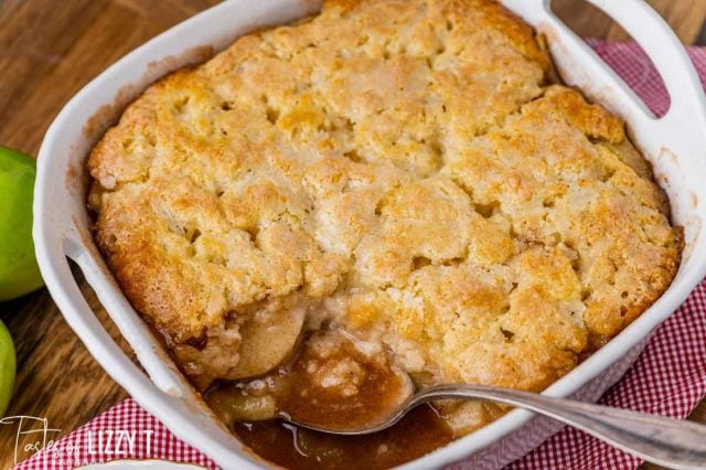 apple cobbler in an 8x8 baking pan with a spoon