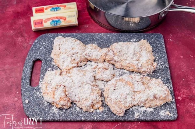 floured chicken resting on a cutting board