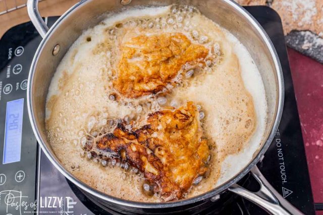 chicken frying in butter in a skillet