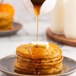 syrup pouring over a stack of pancakes