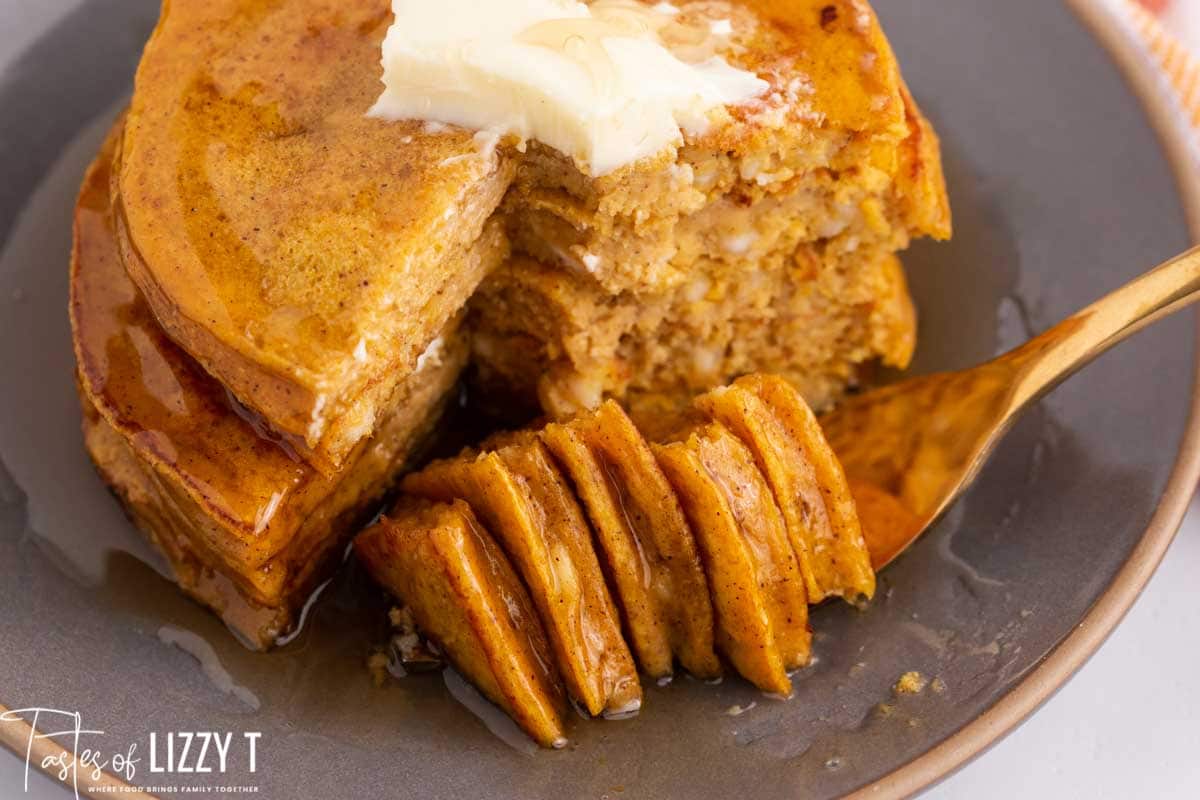 a plate of pancakes with a bite on a fork