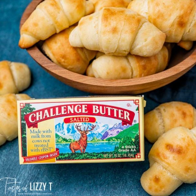 dinner rolls on a table with a box of butter