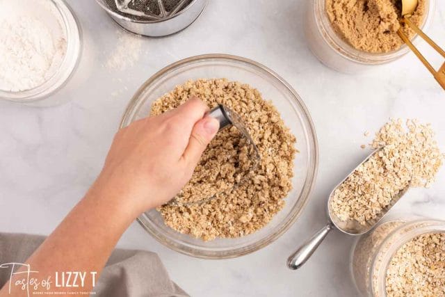 pastry cutter cutting butter into sugar and oats