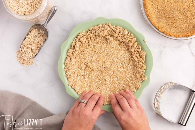 hands pressing pie crust in a pie plate