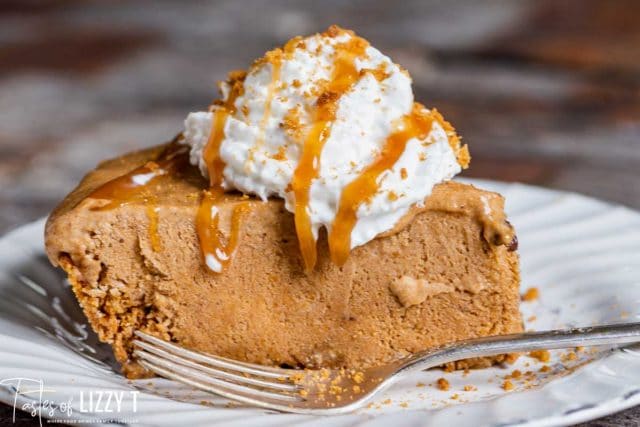 a slice of pumpkin pie with whipped cream and caramel