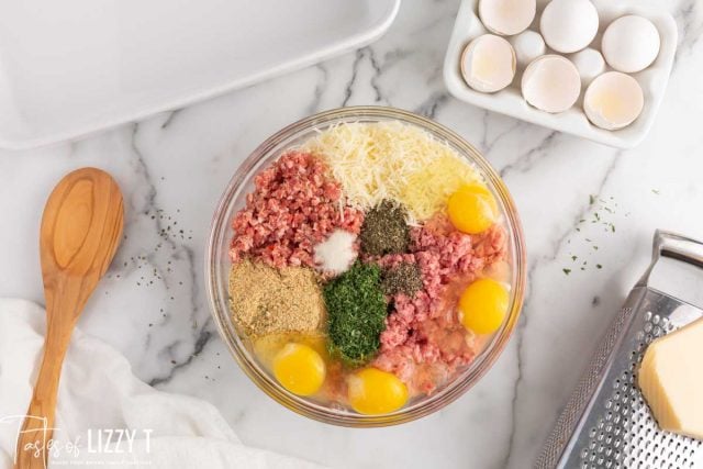 ingredients for meatballs in a glass bowl