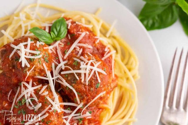 spaghetti and meatballs on a plate with a fork