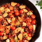 chicken and tomatoes in a skillet