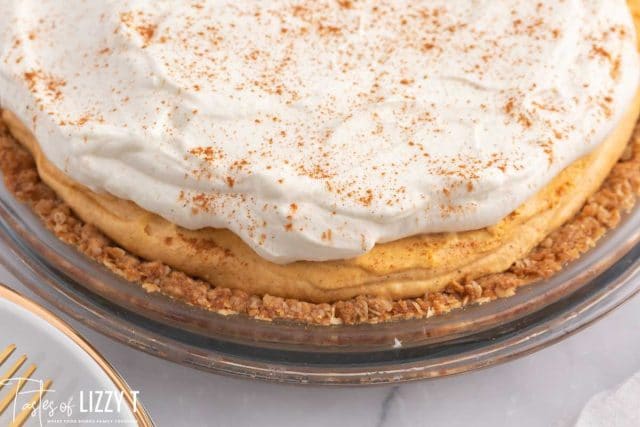 closeup of a pumpkin pie with whipped cream on top
