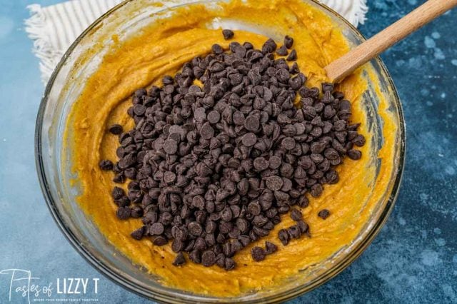 chocolate chips over pumpkin muffins batter in a bowl