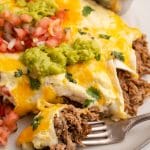 shredded beef enchiladas with guacamole and fresh salsa on a plate