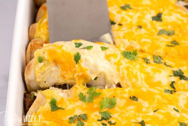 creamy roast beef enchiladas on a baking pan