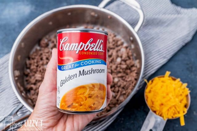 a hand holding a can of golden mushroom soup