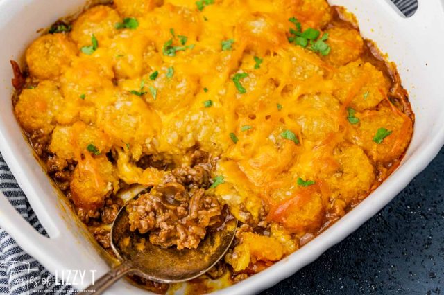 tater tot casserole topped with cheese in a baking dish
