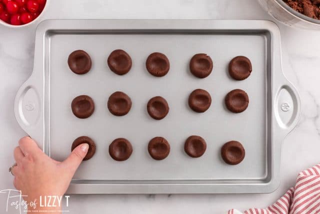 chocolate thumbprint cookies on a baking sheet