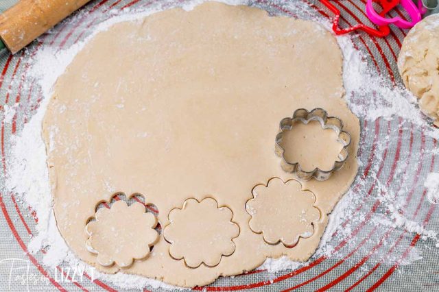 dough rolled out with cookie cutters