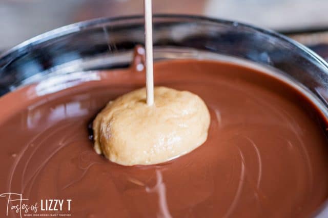 dipping a buckeye in melted chocolate