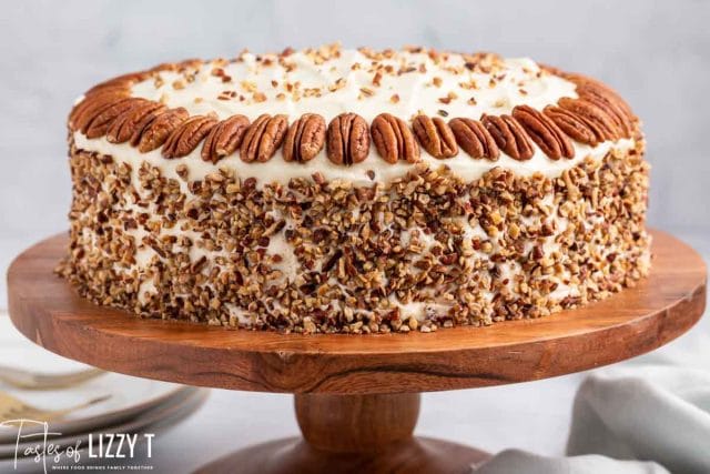 a pumpkin spice cake on a wooden cake plate