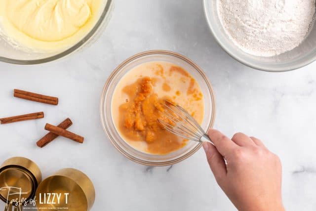 mixing milk and pumpkin in a bowl