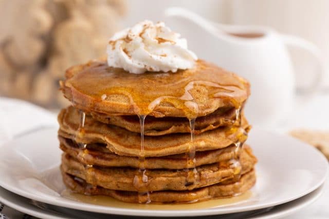 a stack of pancakes with dripping syrup