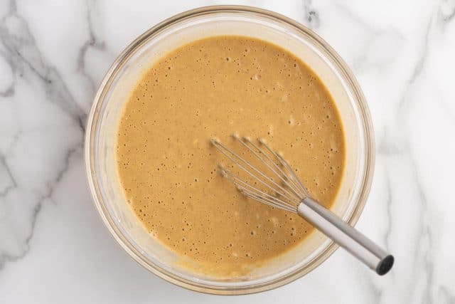 pancake batter in a bowl with a whisk