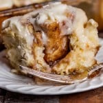 closeup of a cinnamon roll on a plate with a fork
