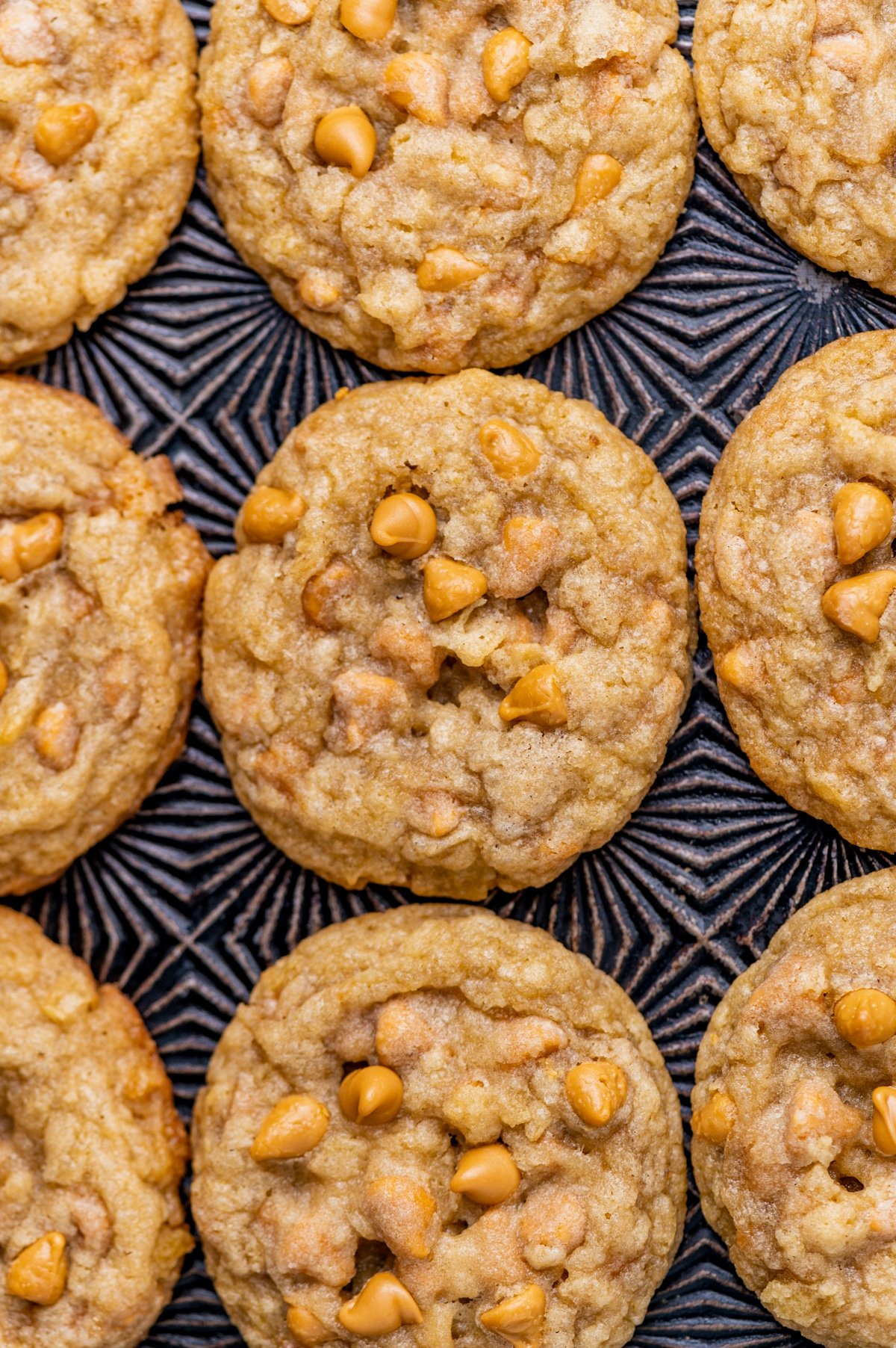 butterscotch potato chip cookies on a patterned baking sheet