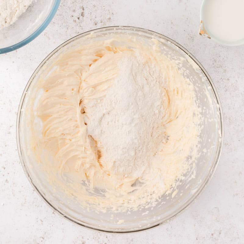 flour over creamed butter, sugar and egg in a bowl