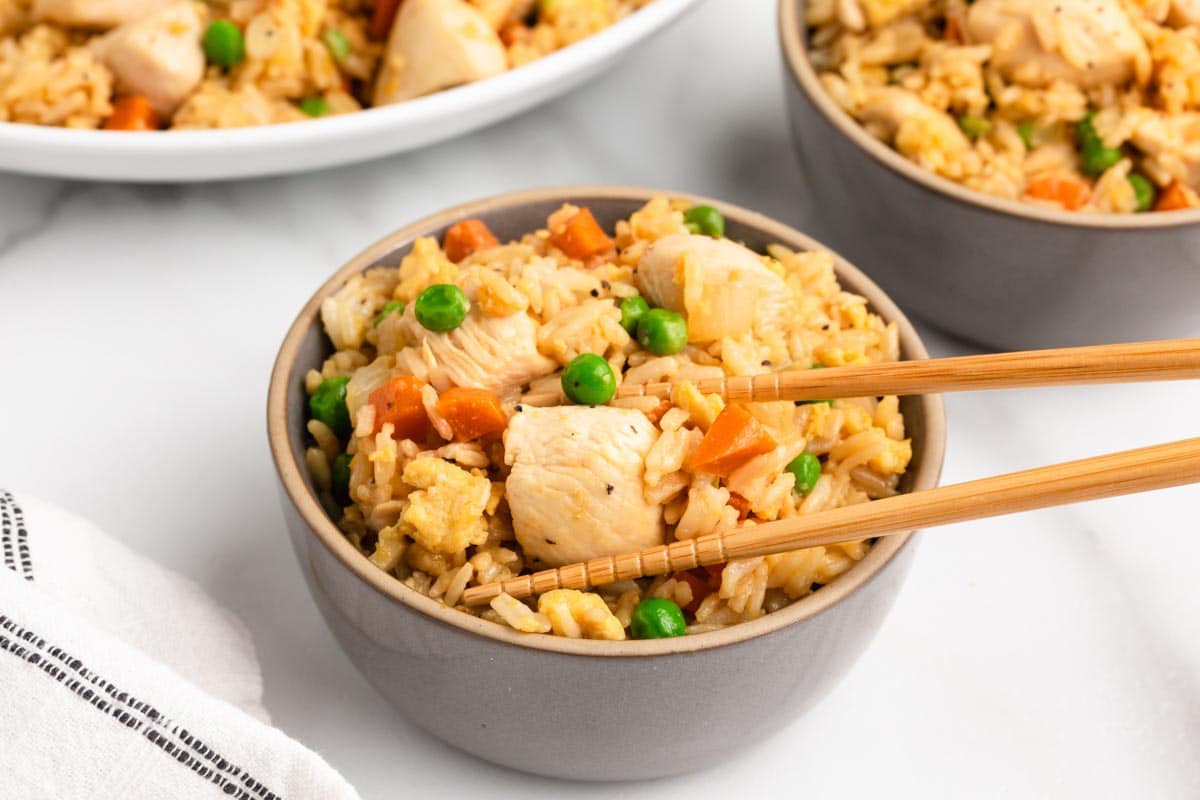 chicken fried rice in a bowl with chopsticks