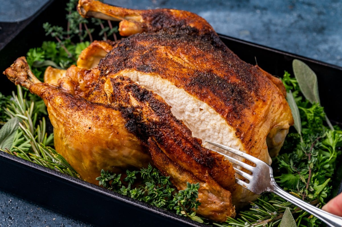a golden brown roast chicken with a cut in it