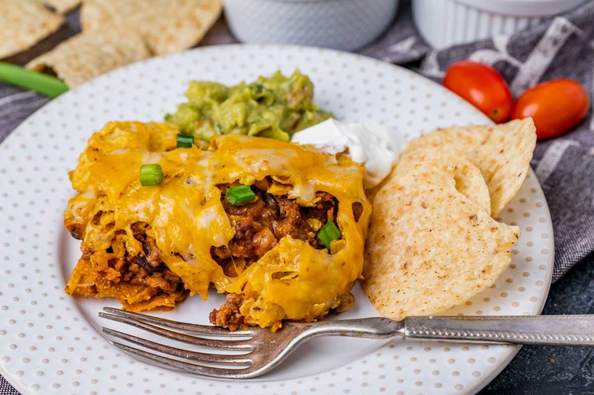 a plate of tortilla chips and enchilada casserole