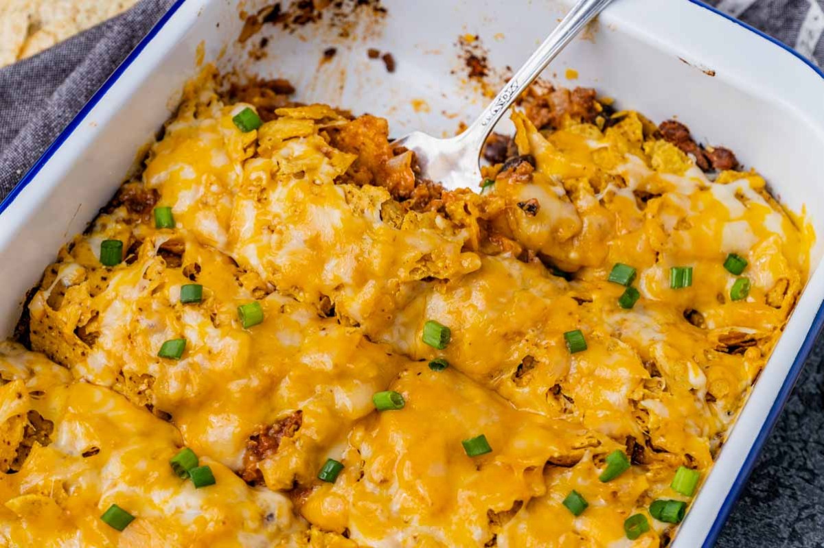 enchilada casserole in a pan with one serving missing