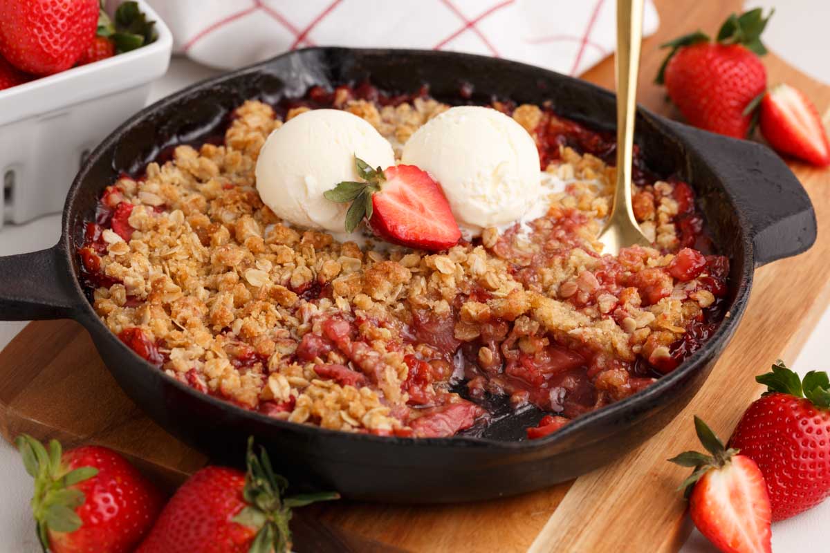strawberry crisp in a skillet with a scooped out