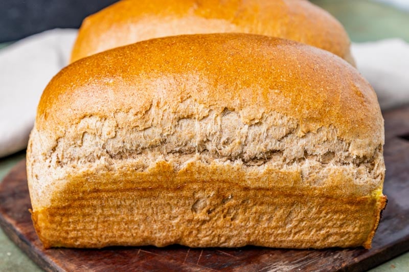 two loaves of wheat bread on a table