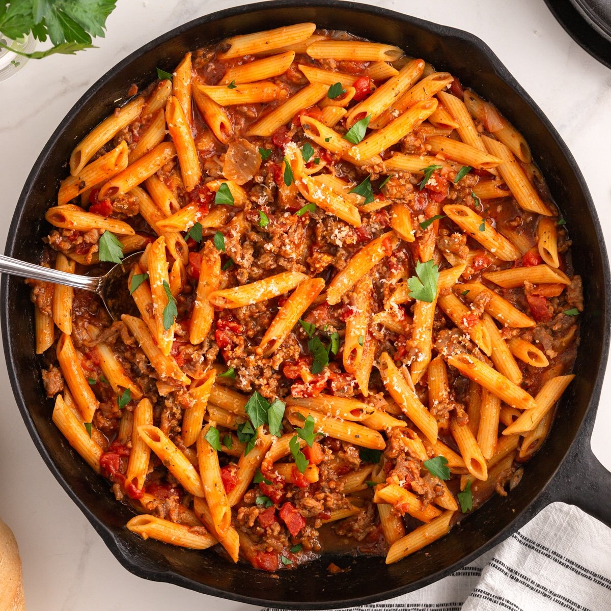 overhead shot of sausage pasta in a cast iron skillet