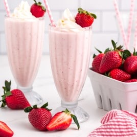 two strawberry milkshakes with straws