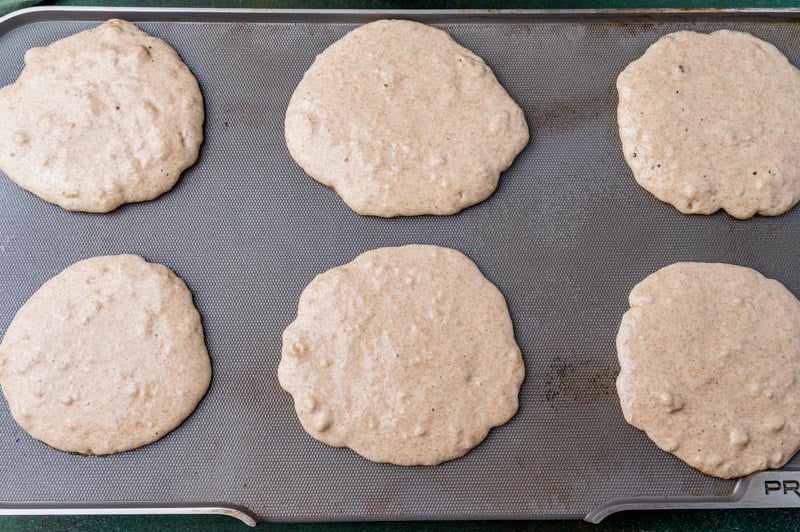 overhead view of uncooked pancakes on a griddle