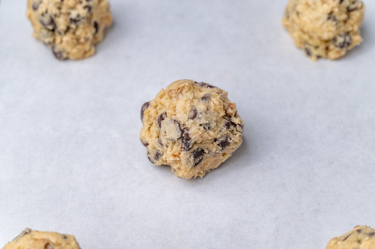 cookie dough balls on a parchment lined baking sheet