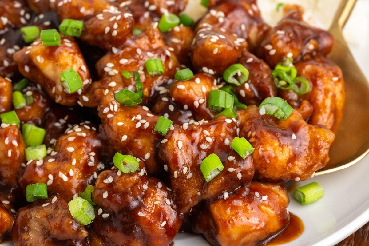 closeup of a plate of general tos's chicken with green onion