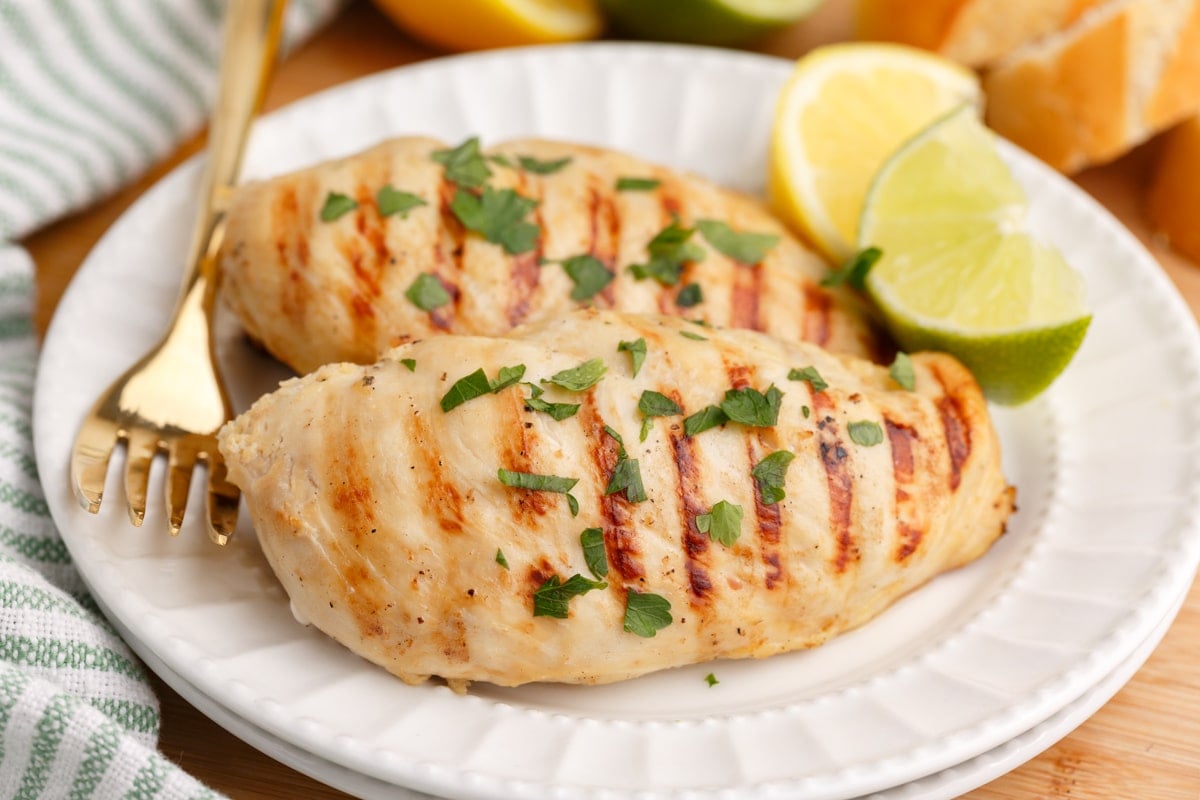 two grilled lemon lime chicken breasts on a plate