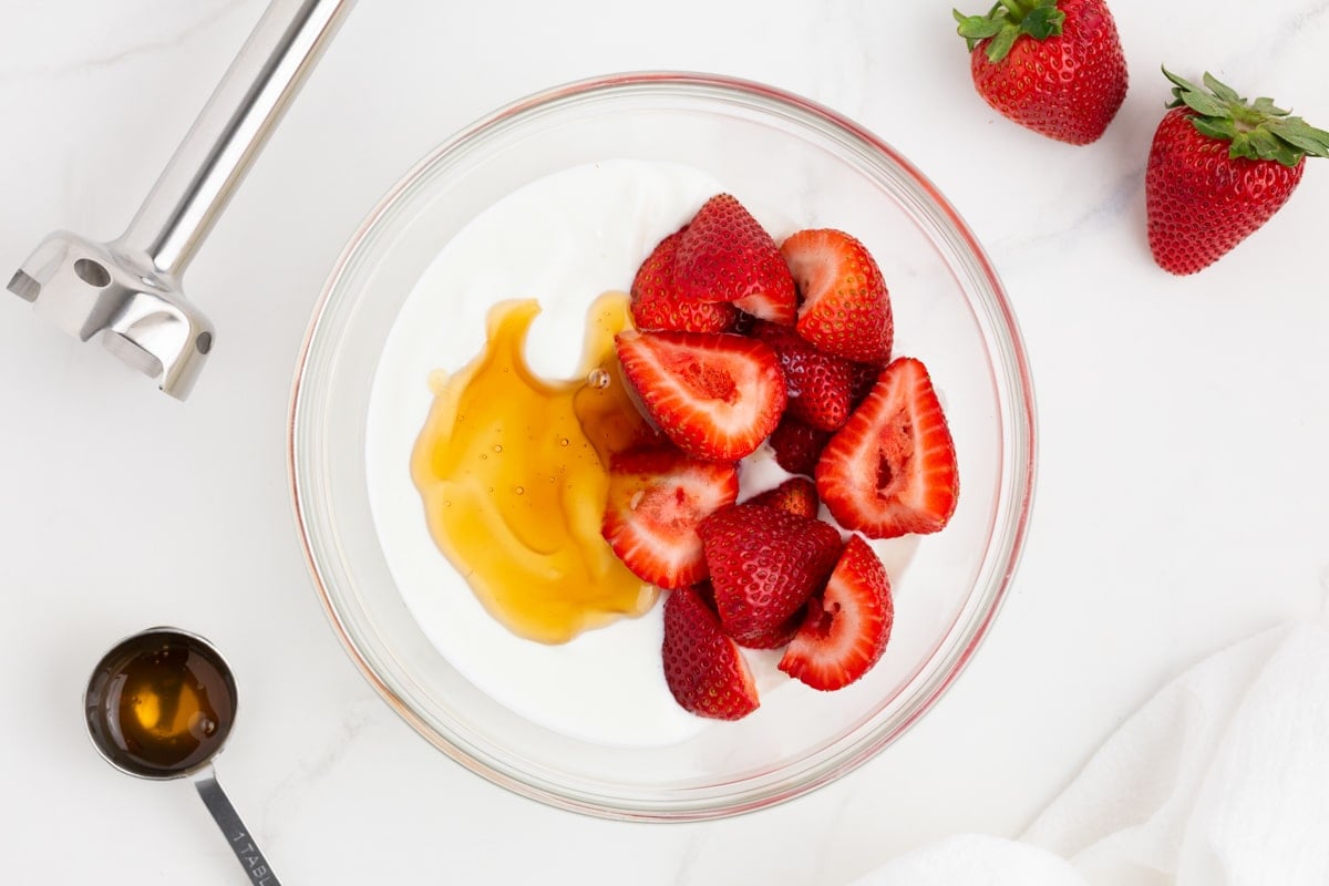 strawberries, yogurt and honey in a glass bowl