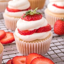 a strawberry shortcake cupcake sitting in a wire rack