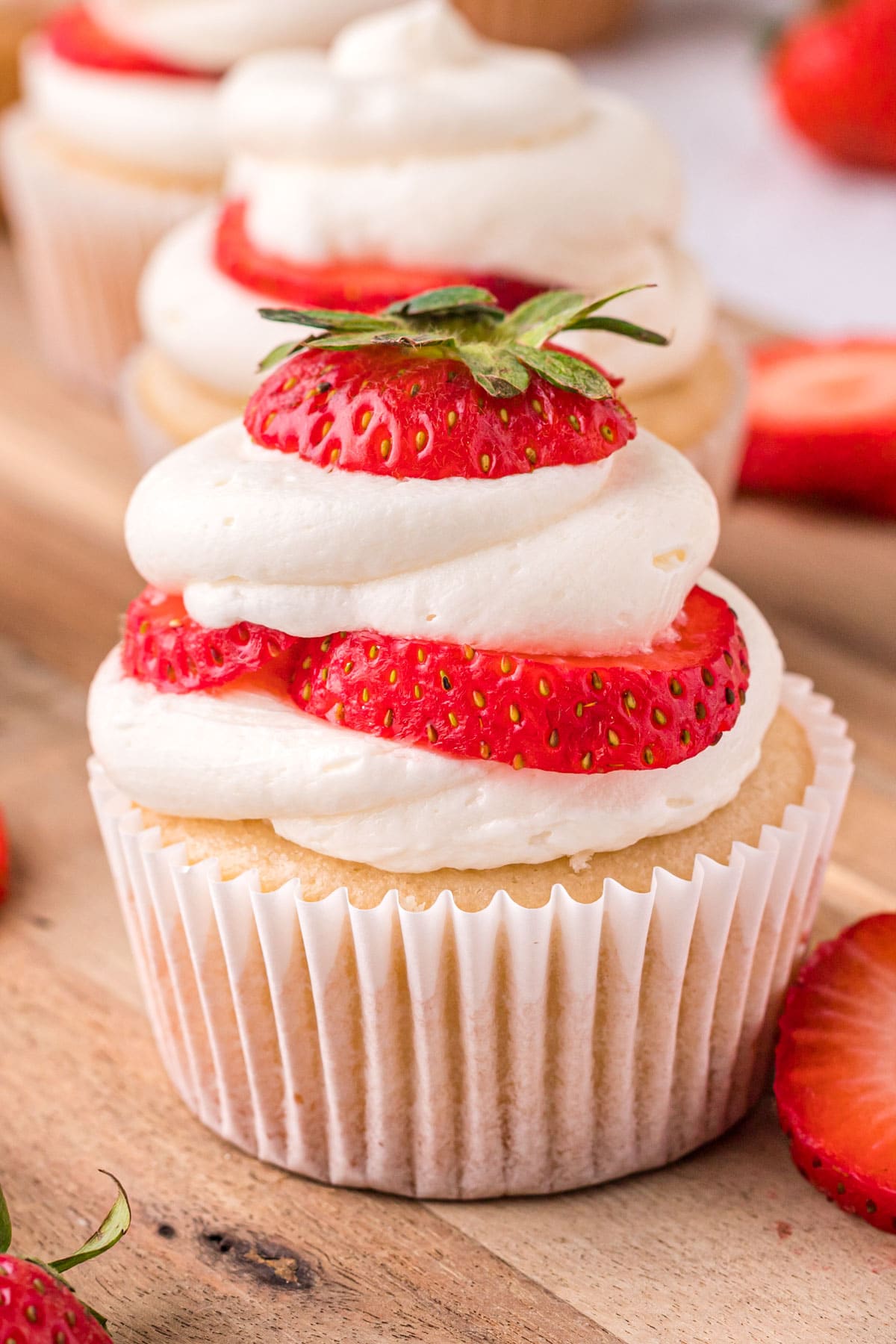 a vanilla cupcake with strawberries and whipped cream