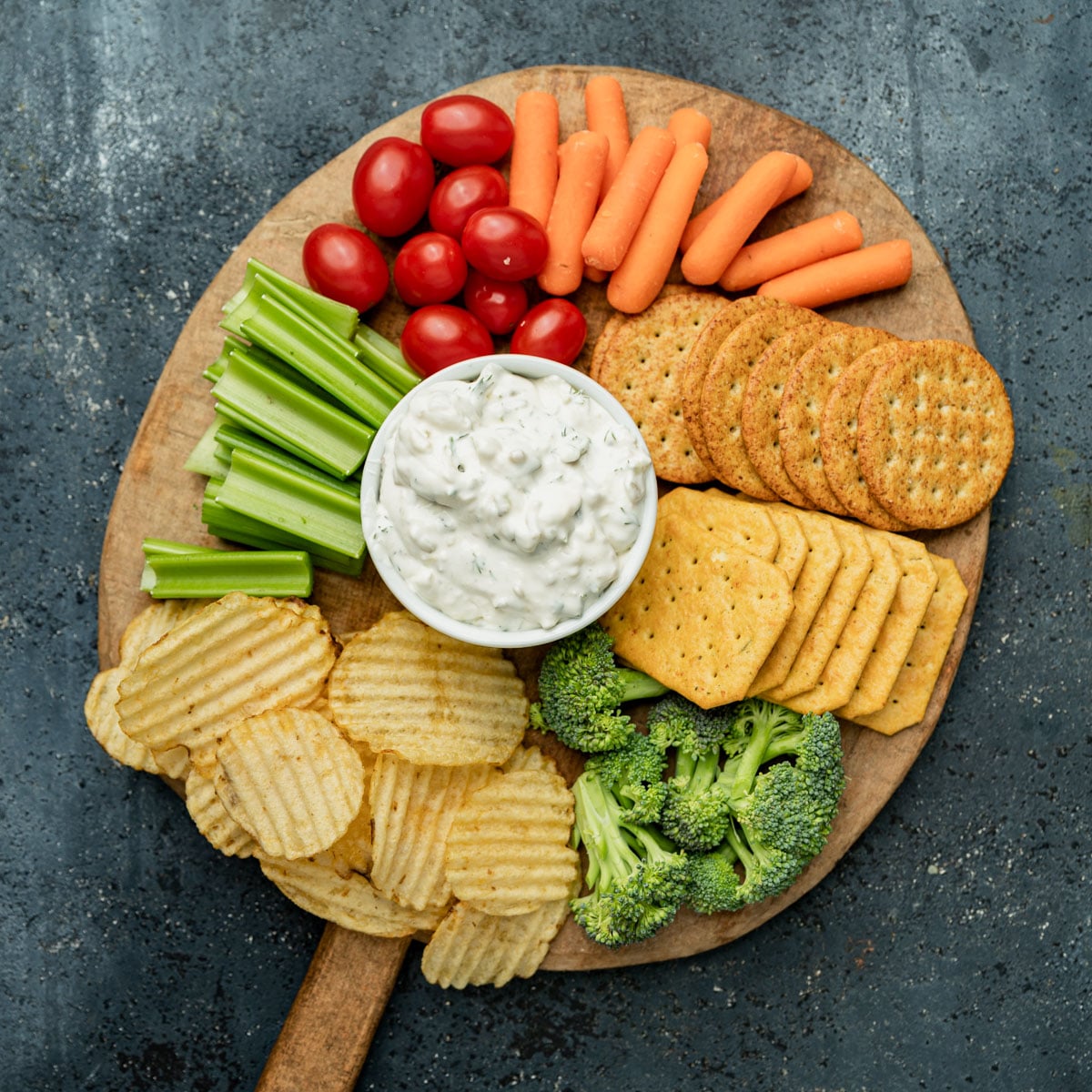 overhead view of a charcuterie board with dill pickle dip