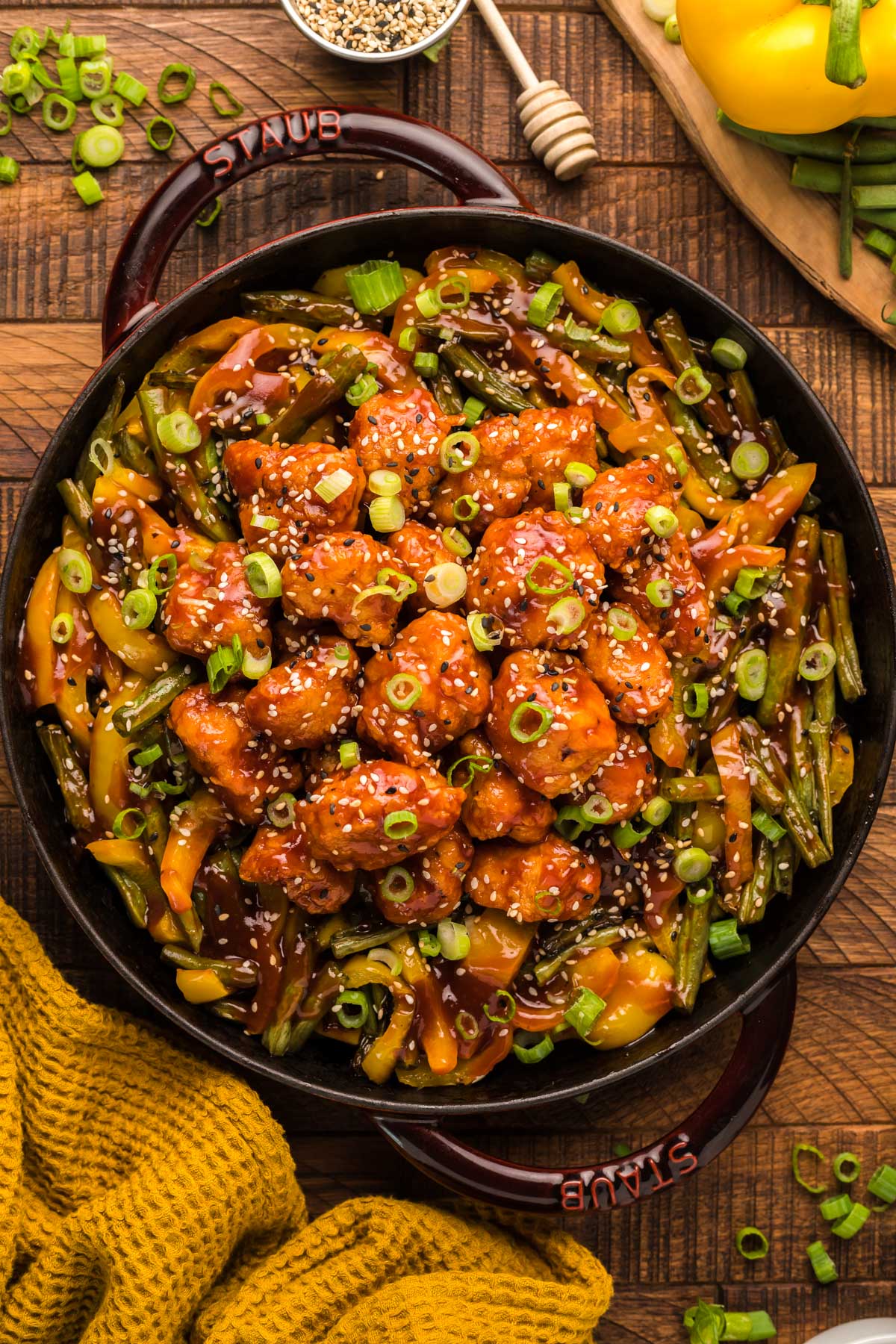 honey sesame chicken with green beans and peppers in a pan