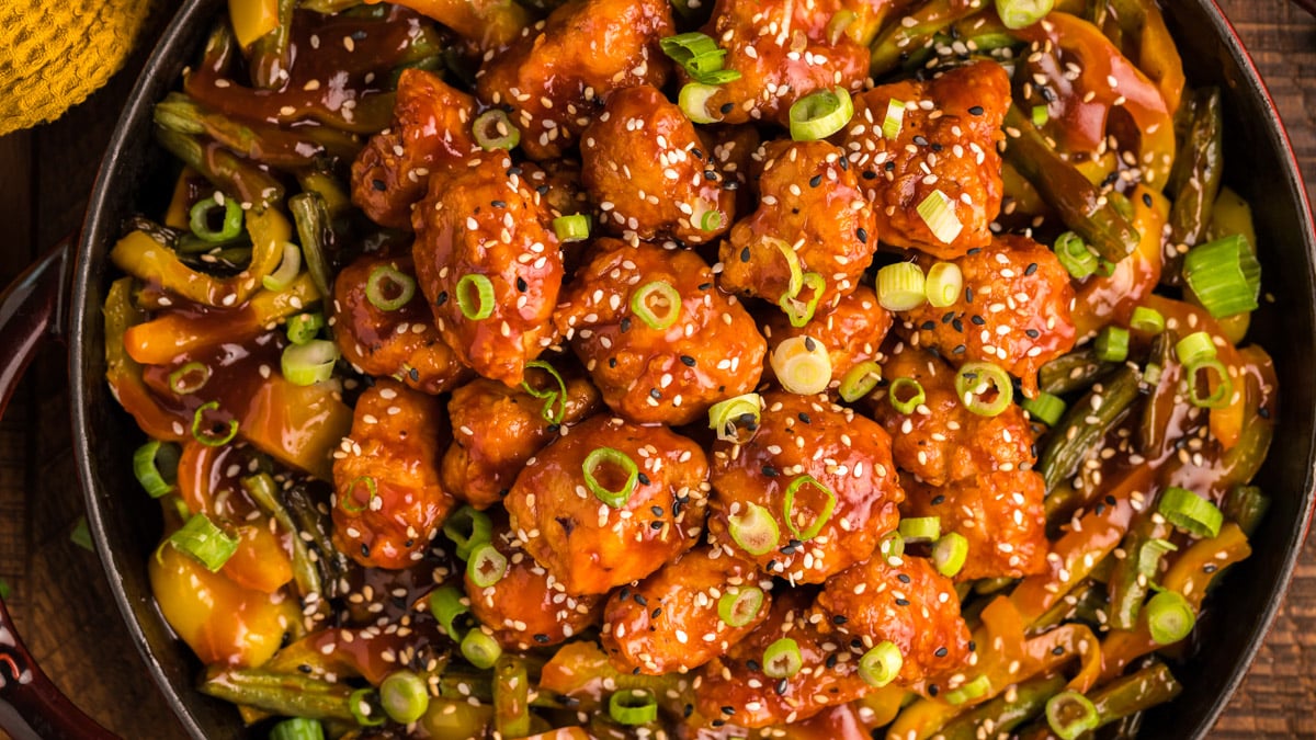 overhead shot of honey sesame chicken and veggies in a pan