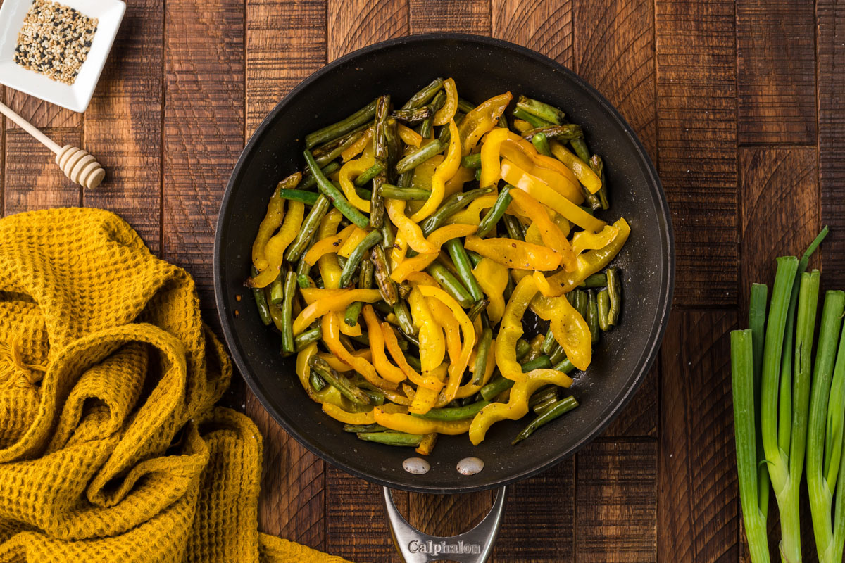 sautéed peppers and green beans in a pan