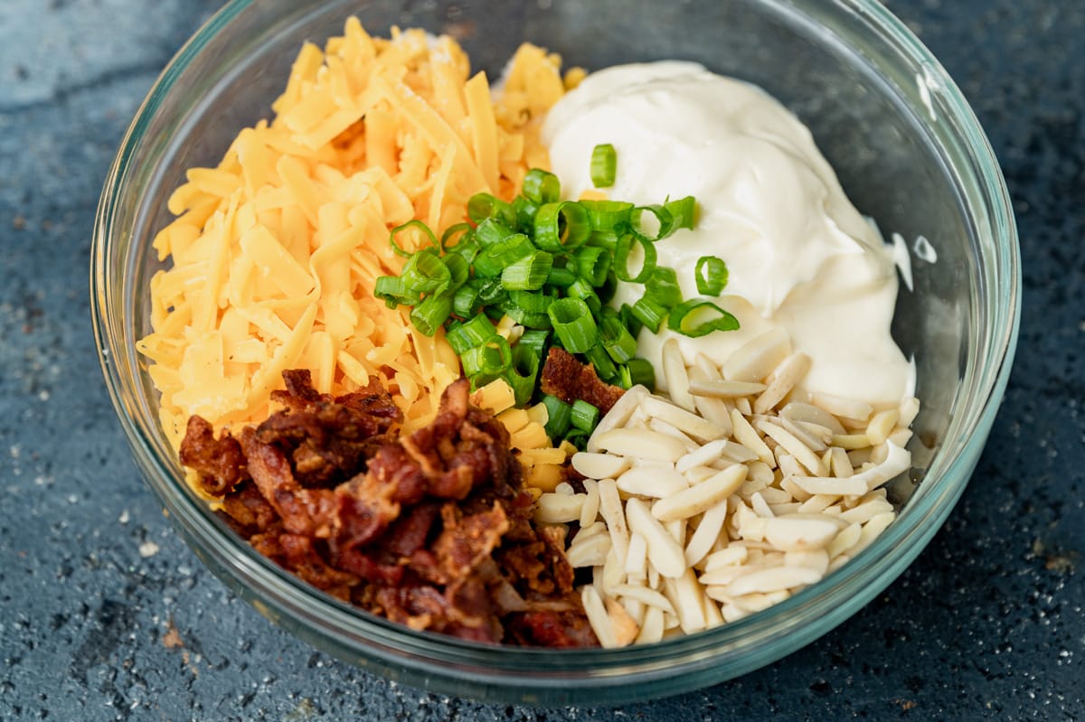 cheese, bacon, almonds, onions and mayo in a bowl